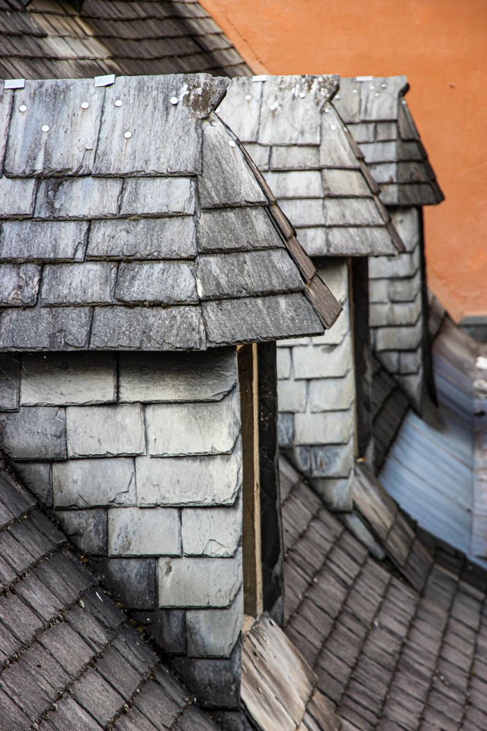 Mastering the First Impression: Your intriguing post title goes here Close-up of traditional slate rooftops in Lourdes, Occitania, showcasing classic French architecture.